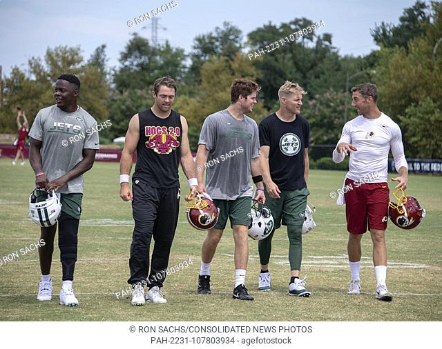 New York Jets and Washington Redskins quarterbacks come off the field together after participating in a joint training camp practice with the Washington...