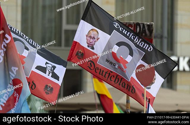 17 October 2021, Saxony, Dresden: Participants display Qanon flags at an event marking the 7th anniversary of the Pegida movement