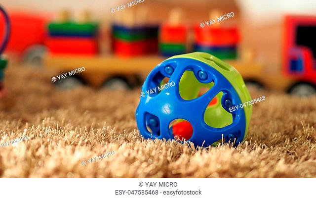 Many colorful baby wood toys on light brown color carpet which include ball, airplane, bus and others that helps development baby's EQ and IQ and make baby have...