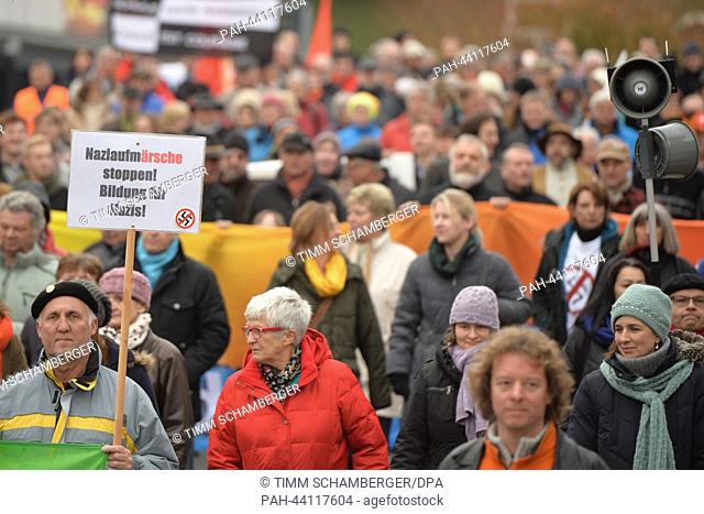 A man holds a poster reading 'Stop Nazi marches! Education for Nazis' during a protest event against a neo-Nazi march in Wunsiedel, Germany, 16 November 2013