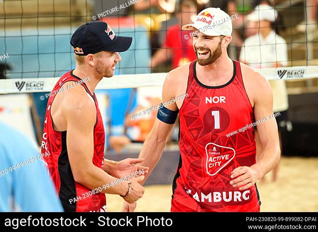 20 August 2023, Hamburg: Volleyball/Beach: Beach Pro Tour, match for 3rd place, Norway - Brazil. Norway's Christian Sorum (l-r) and Anders Mol laugh together...