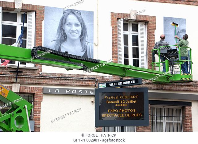 POSTING OF THE GIANT PHOTOS WITH AN AERIAL LIFT ON THE WALLS (THE POST OFFICE) OF THE TOWN FOR THE RUGL'ART CULTURAL FESTIVAL, RUGLES, (27) EURE, FRANCE