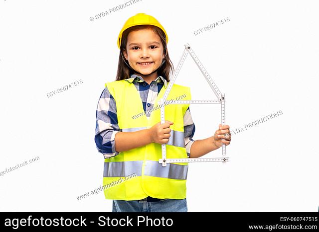little girl in helmet with ruler in shape of house