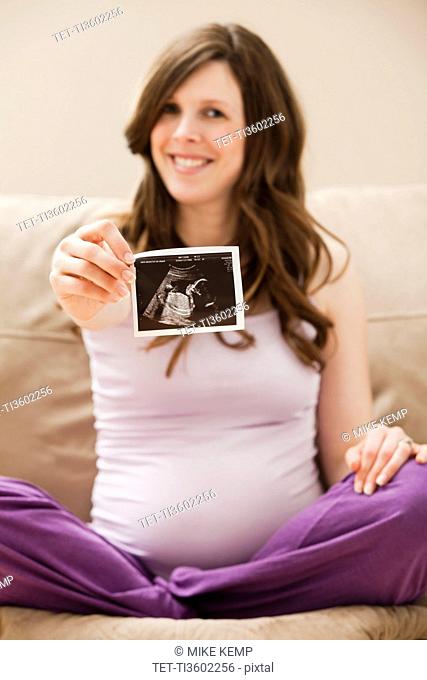 USA, Utah, Lehi, Young pregnant woman showing CT image of unborn baby