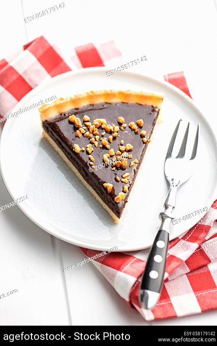 Sweet chocolate pie with crushed nuts on plate