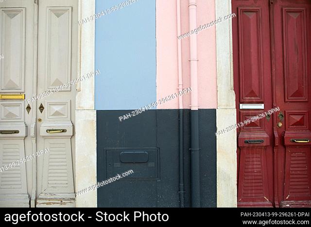 PRODUCTION - 31 March 2023, Portugal, Coimbra: The facades and doors of two adjoining apartment buildings in the city center are painted in bright colors
