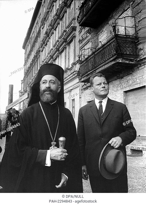 Cypriot Archbishop Makarios and Berlin's Lord Mayor Willy Brandt (R) visit the walled-in houses standing directly on the sector border on Bernauer Street in...