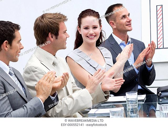 Smiling attractive businesswoman applauding in a meeting