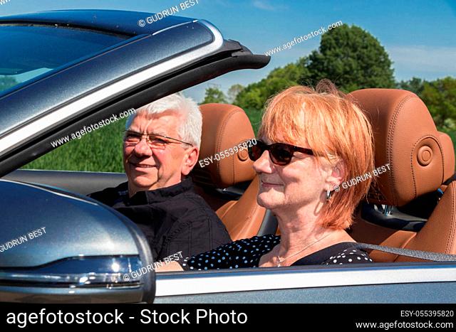 Beautiful older woman with partner in sports car