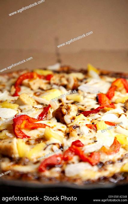 Barbeque chicken, red bell pepper, onion, pineapple pizza in its carryout box