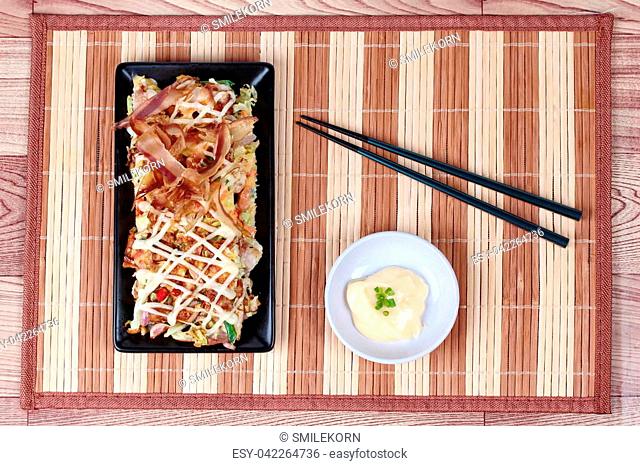 Japan pizza as ""Okonomiyaki"" is fried and grill mixed vegetable flour with meat topped sweet sauce , mayonnaise or salad cream and sliced dried yellowfin tuna...