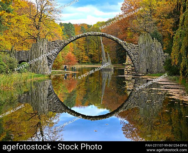 dpatop - 07 November 2023, Saxony, Kromlau: The Rakotzbrücke bridge in the autumnal azalea and rhododendron park in Kromlau in the district of Görlitz near the...