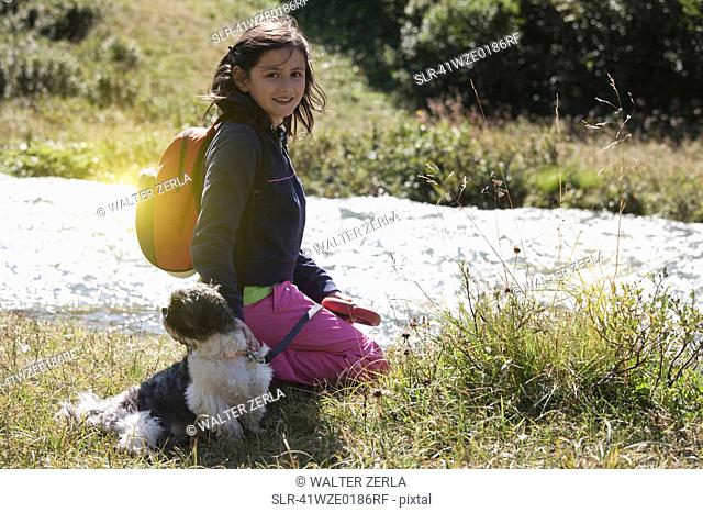 Smiling girl walking dog in field