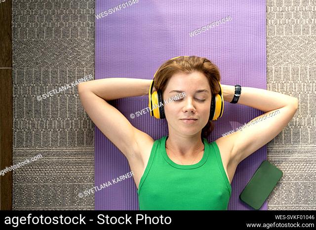 Woman with eyes closed relaxing on mat