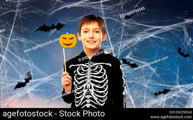 boy in halloween costume of skeleton with pumpkin