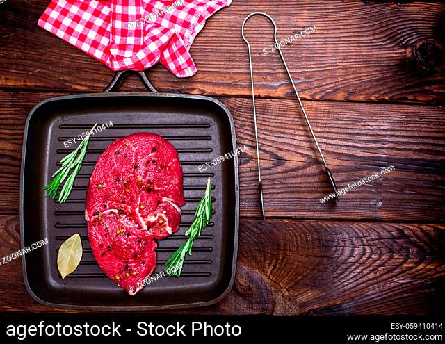 raw beef steak on a black quart pan, empty space on the right