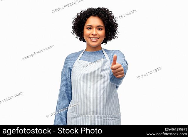 smiling woman in apron showing thumbs up