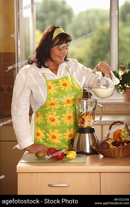 Woman pours milk to fruits in blender, prepare, stand mixer, mix, pours, pour, pour in, add, mix, add to, fruit basket, basket, hair band
