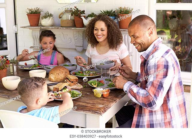 Family At Home Eating Outdoor Meal Together
