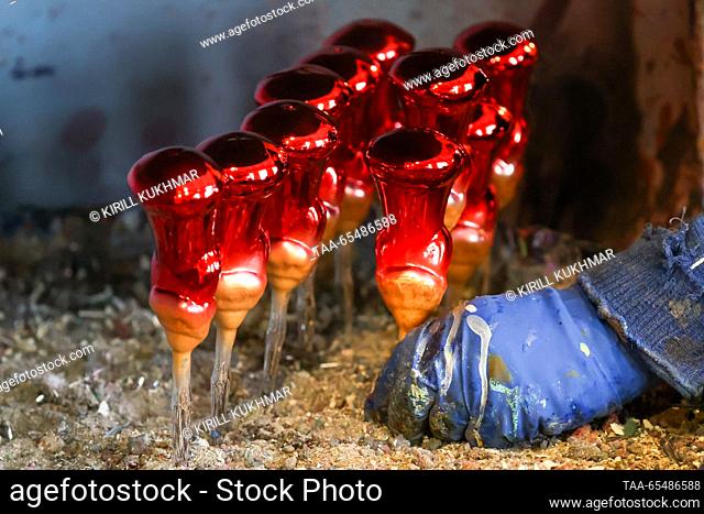 RUSSIA, KRASNOYARSK - DECEMBER 5, 2023: A worker paints baubles at Biryusinka, an enterprise producing handmade Christmas decorations