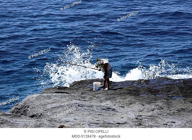 A fisherman fishing on the Balata dei Turchi, a gorgeous bay on the Island of Pantelleria (Italy), May 2015