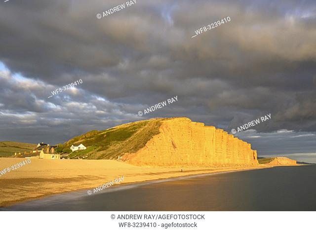 The sandstone cliffs at East Cliff near Bridport on Dorset's Jurassic Coast World Heritage Site captured from the pier at West Bay on an evening in mid...