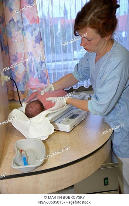 new born baby being weighed