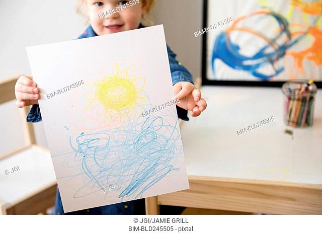 Caucasian girl showing drawing on paper