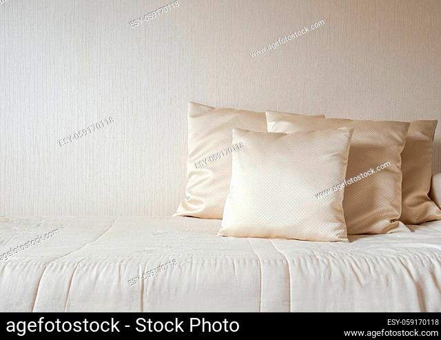 silk pillow and blanket against cream colored wall in bedroom modern and luxurious style, modern decoration, design, architecture concept copy space luxury