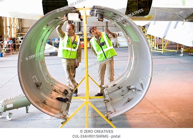 Aircraft workers checking airplane part