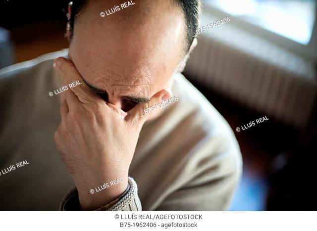 Worried man with hand on face