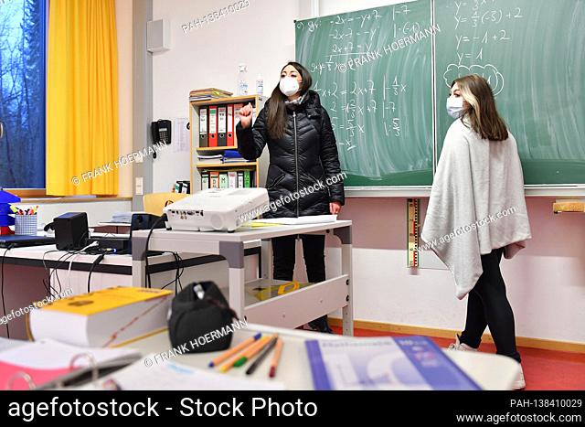School lessons in times of the coronavirus pandemic. Teacher and student, student stand at a blackboard, school blackboard and do math problems
