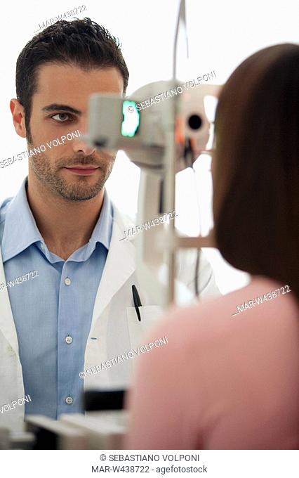 young woman having her eye's tested by doctor