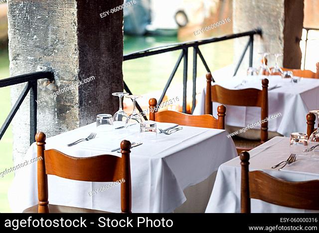 table setting for a lovey dinner. Empty glasses set in restaurant. Part of interior. napkins, plates, and eating utensils