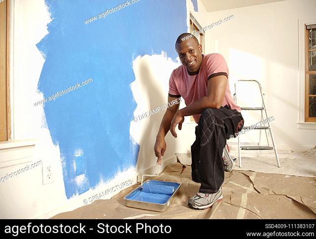 African American man painting wall