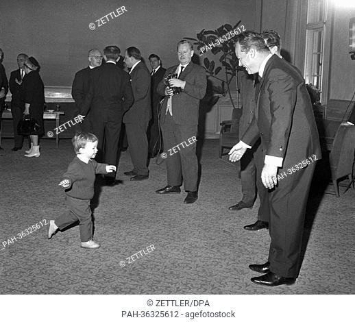 Mathias Brandt (l), son of Ruling Mayor of Berlin Willy Brandt (r, front), runs towards his father to congratulate him to his 50th birthday