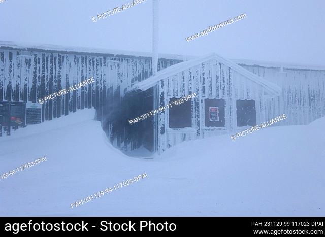 29 November 2023, Saxony-Anhalt, Schierke: Meter-high snowdrifts stand at a building on the Brocken. Strong winds and snow have brought train services to the...