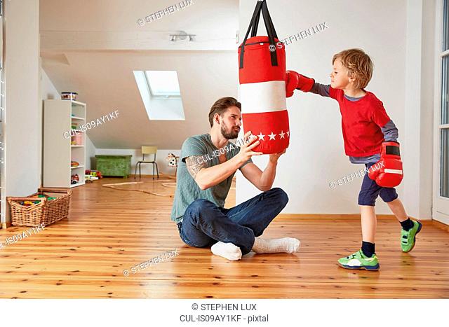 Father holding punchbag for son