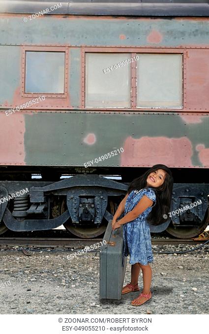 Beautiful little girl going on vacation with a suitcase