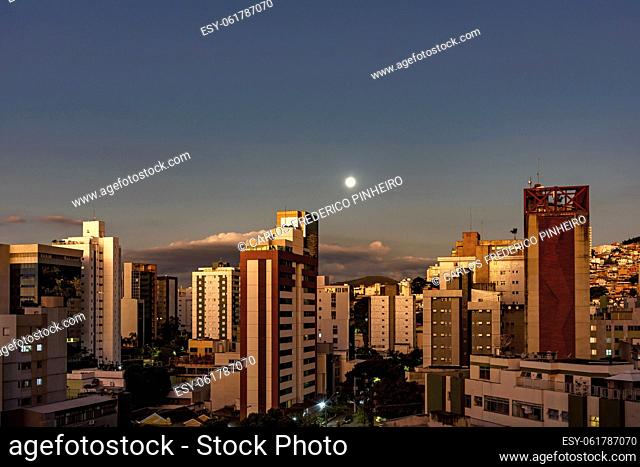 City of Belo Horizonte in the southeastern region of Brazil seen at dusk with the full moon over the buildings,