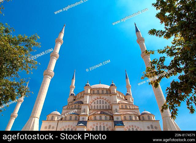 Exterior bottom view of Adana Sabanci Mosque, with six minarets, on bright blue sky background