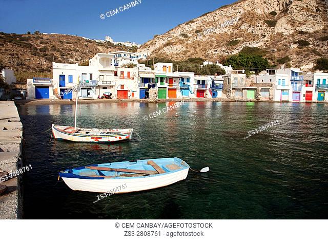 Local people swimming in the sea in front of the traditional fisherman houses with the impressive boat shelters also known as 'Syrmata' in Klima village, Milos