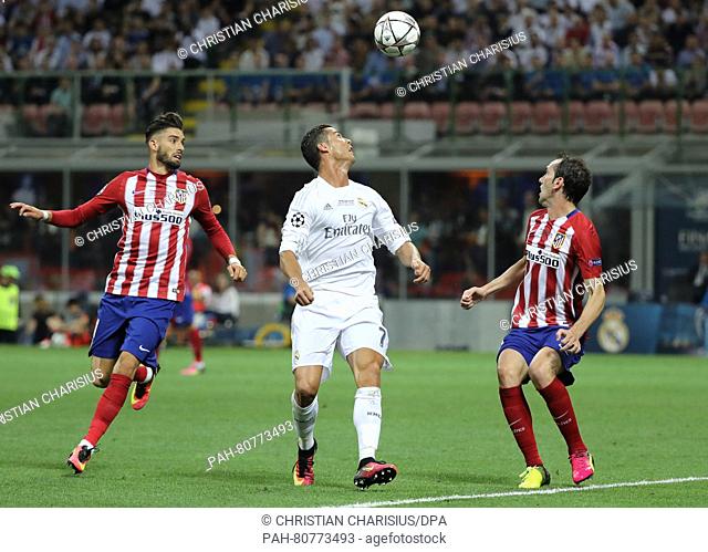 Atletico's Yannick Carrasco (L) and Diego Godin vie for the ball with Real's Cristiano Ronaldo (C) during the UEFA Champions League Final between Real Madrid...