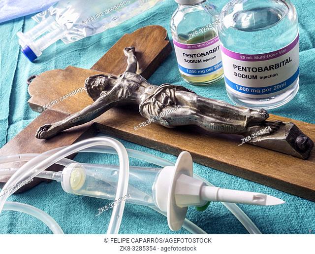 Vial with doses of pentobarbital next to a crucifix, Debate between life and death, religious belief in the face of euthanasia, conceptual image