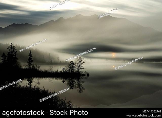 The small chapel Maria rast near Krün shines like a glimmer of hope through the fog over the small moor lake in the Bavarian Alps
