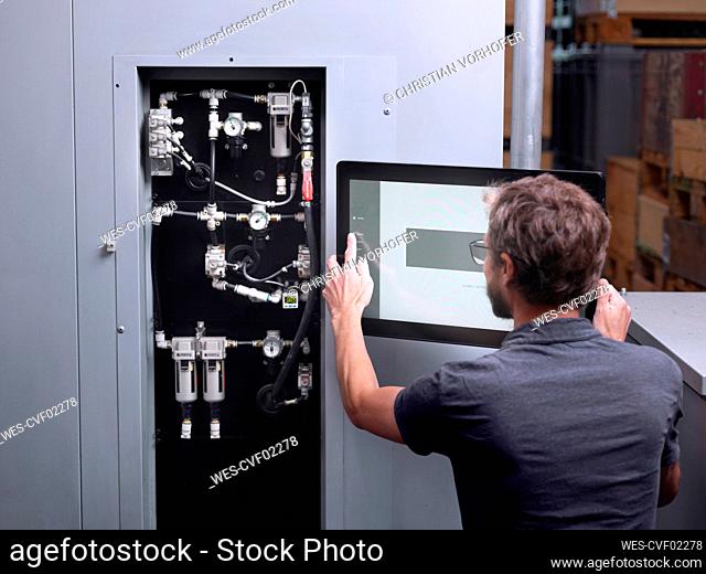 Technician operating machine in modern factory