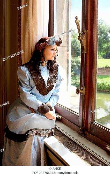 Vintage portrait of a victorian lady standing by a castle window.Shot in the antique castle ""Den Brandt"" in Antwerp, Belgium (with signed property release for...