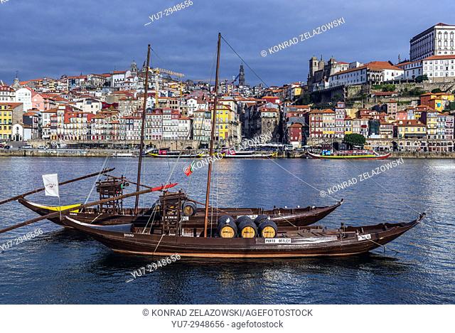 Sandeman and Porto Cruz Port wine boats called Rabelo Boats on a Douro River in Vila Nova de Gaia city. Porto city river bank on background