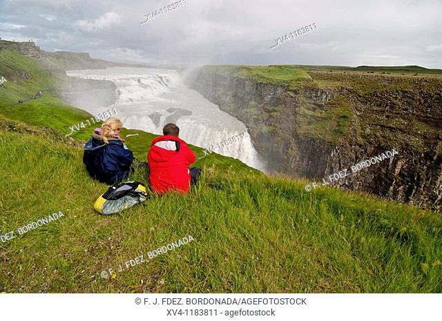 Couple of tourist at Gullfoss waterfall  The golden waterfall is located on the Hvitá river