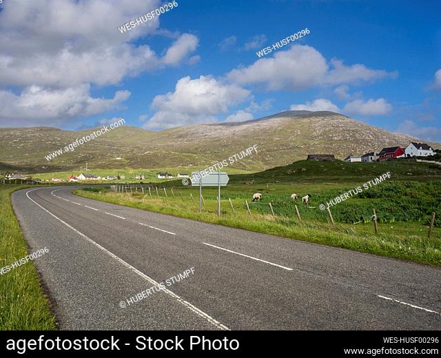 UK, Scotland, Empty asphalt road in¶ÿOuter Hebrides with hills and pastures in background